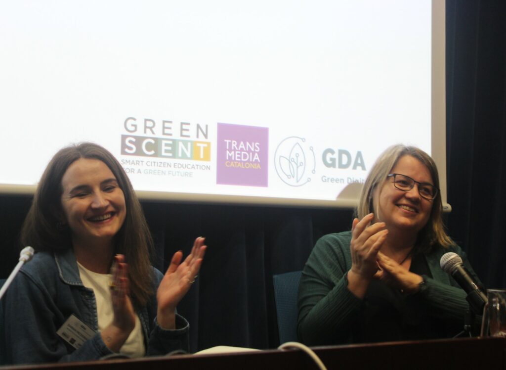 Sarah McDonagh and Anna Matamala are clapping their hands, and they are smiling.